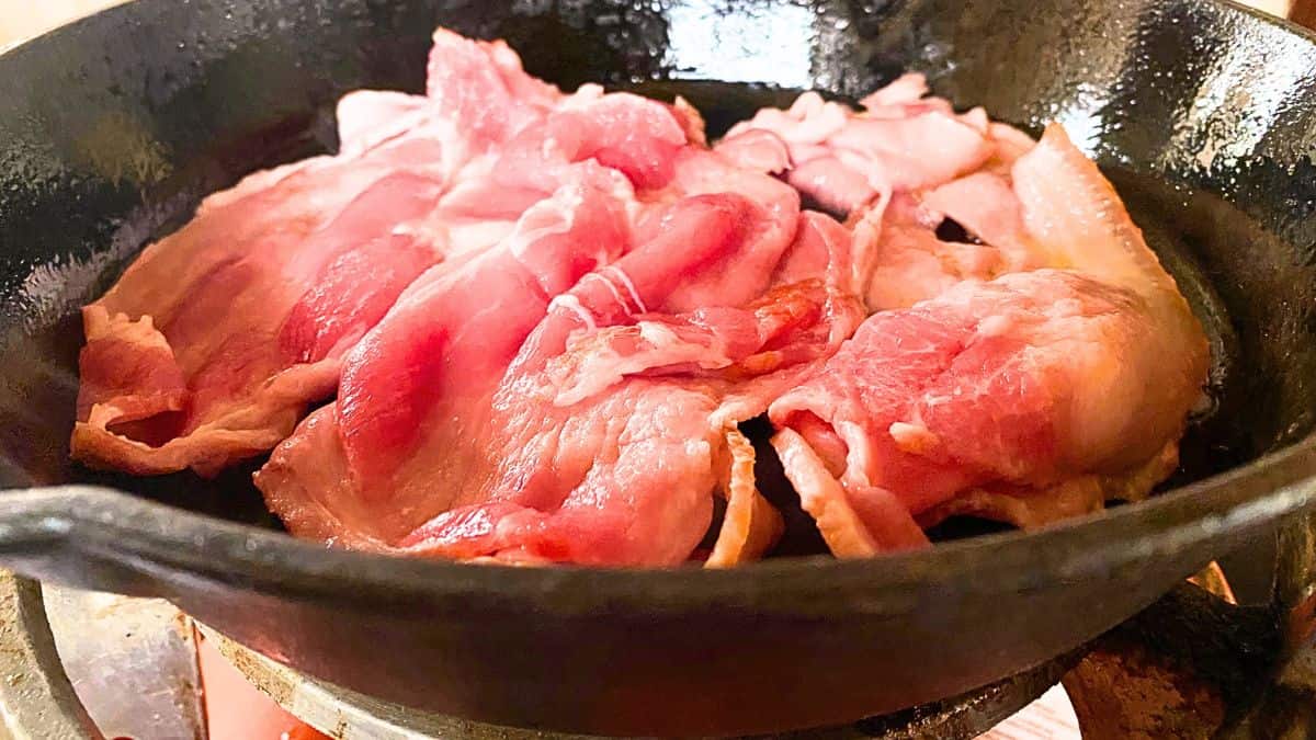 Bacon being fried in a skillet